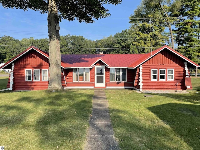 log cabin featuring log exterior, a front lawn, and metal roof