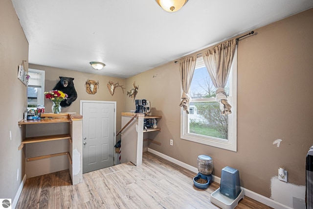 505 S Cherry St, Kalkaska, MI 49646 - miscellaneous room with wood finished floors, baseboards, and an upstairs landing
