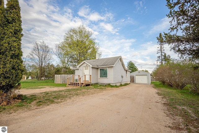 505 S Cherry St, Kalkaska, MI 49646 - view of front of house featuring dirt driveway, an outdoor structure, a garage, and a chimney