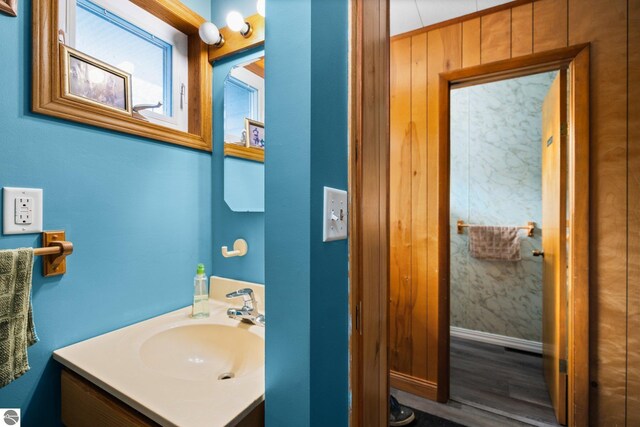 8817 Wilson Rd, Buckley, MI 49620 - bathroom featuring vanity, wood finished floors, and baseboards
