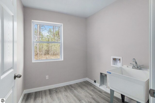 5203 NE Myers Rd, Kalkaska, MI 49646 - washroom featuring washer hookup, baseboards, and light wood finished floors