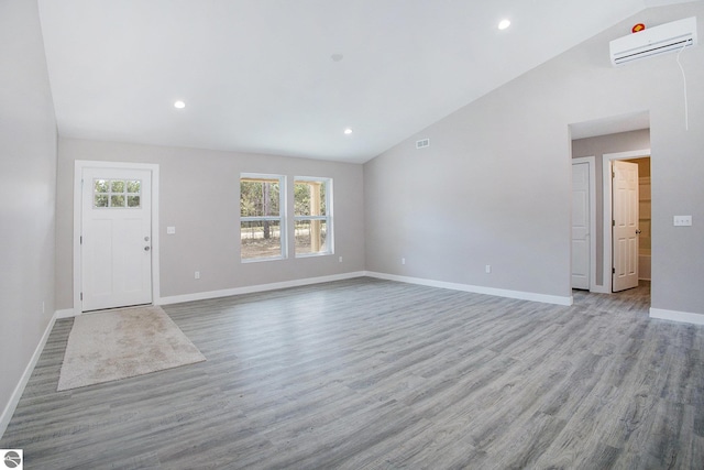 5203 NE Myers Rd, Kalkaska, MI 49646 - entrance foyer featuring a wall mounted AC, vaulted ceiling, healthy amount of natural light, wood finished floors, and baseboards