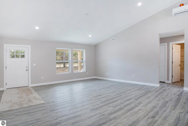 5203 NE Myers Rd, Kalkaska, MI 49646 - unfurnished living room featuring a wall mounted air conditioner, plenty of natural light, baseboards, and recessed lighting