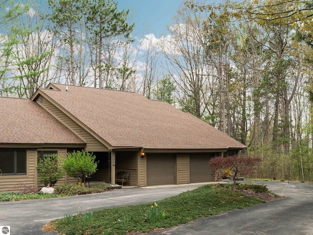 6307 Summit Ct, Traverse City, MI 49686 - view of front of house featuring asphalt driveway, a shingled roof, and a garage