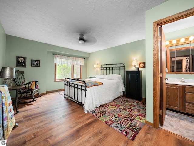 6307 Summit Ct, Traverse City, MI 49686 - bedroom with wood finished floors, baseboards, a textured ceiling, and a ceiling fan