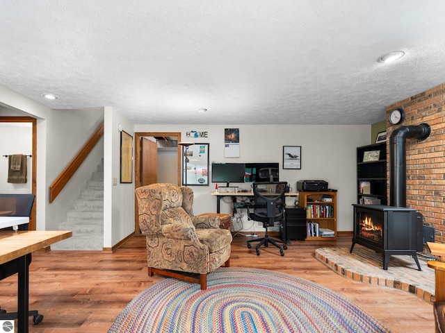 6307 Summit Ct, Traverse City, MI 49686 - office space with a textured ceiling, baseboards, a wood stove, and wood finished floors