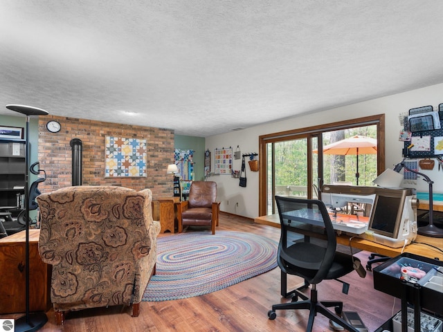 6307 Summit Ct, Traverse City, MI 49686 - office space with a wood stove, a textured ceiling, and wood finished floors