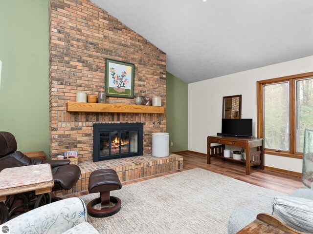 6307 Summit Ct, Traverse City, MI 49686 - living room featuring lofted ceiling, a fireplace, and wood finished floors