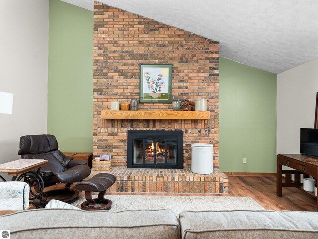 6307 Summit Ct, Traverse City, MI 49686 - living area with lofted ceiling, wood finished floors, a fireplace, and a textured ceiling