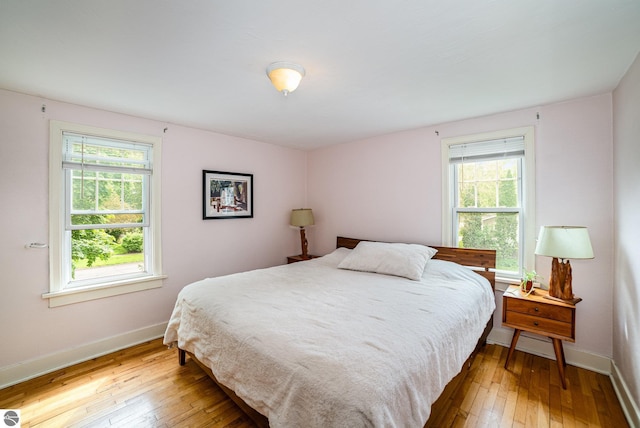 618 E Illinois St, Mount Pleasant, MI 48858 - bedroom with hardwood / wood-style flooring, multiple windows, and baseboards