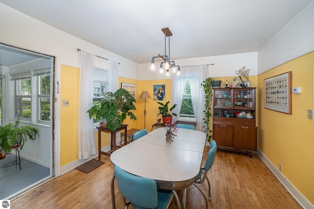 618 E Illinois St, Mount Pleasant, MI 48858 - dining area featuring light wood finished floors, baseboards, and a chandelier