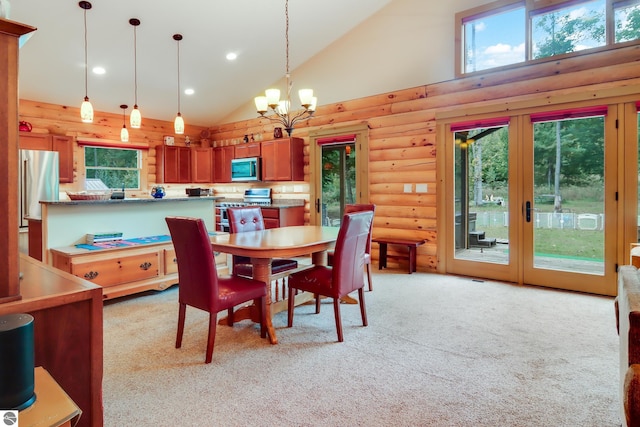 dining room with high vaulted ceiling, french doors, rustic walls, healthy amount of natural light, and a chandelier