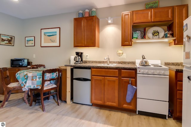 kitchen with white electric range, fridge, a sink, and brown cabinets