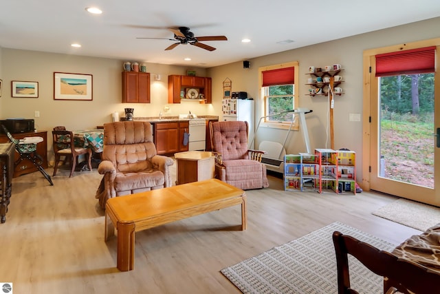 living area featuring light wood-type flooring, a ceiling fan, and recessed lighting