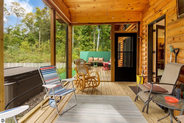 sunroom featuring a jacuzzi, outdoor lounge area, and vaulted ceiling