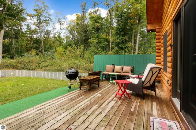 wooden terrace with an outdoor hangout area, a yard, and a grill