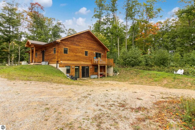 rear view of house with log siding and a wooden deck