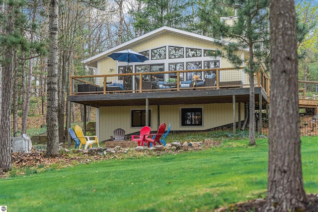 224 Island View Dr, Traverse City, MI 49696 - back of property featuring a wooden deck, a lawn, and a fire pit