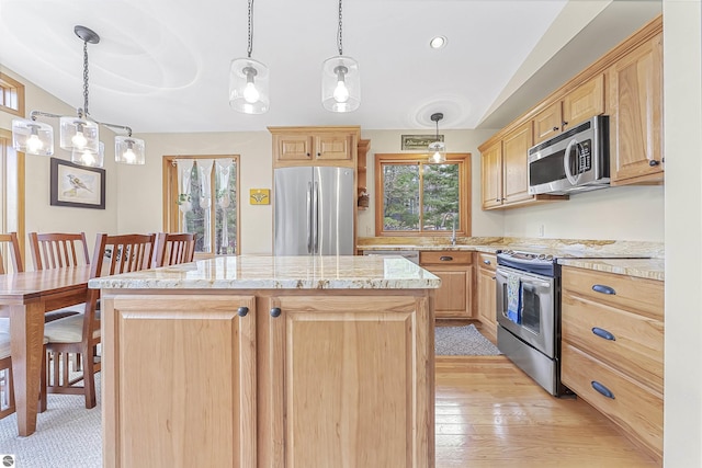 224 Island View Dr, Traverse City, MI 49696 - kitchen with stainless steel appliances, light brown cabinets, a center island, and a sink