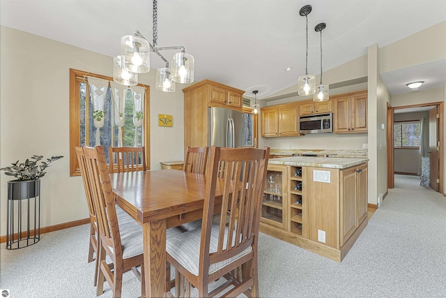 224 Island View Dr, Traverse City, MI 49696 - dining space with vaulted ceiling, a chandelier, light carpet, and baseboards