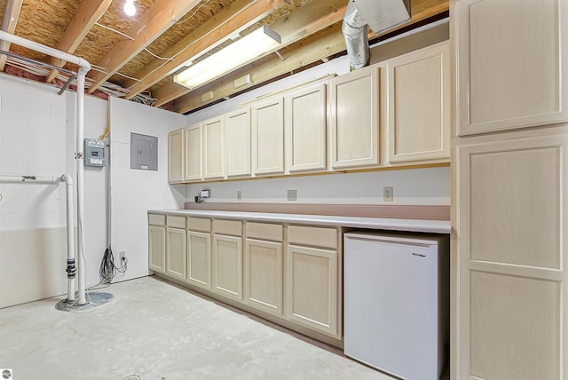 224 Island View Dr, Traverse City, MI 49696 - kitchen with refrigerator, light countertops, concrete floors, and electric panel