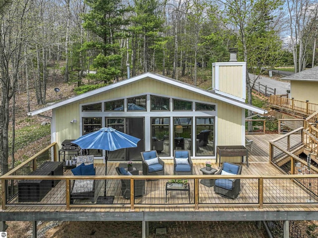 224 Island View Dr, Traverse City, MI 49696 - rear view of property with a wooden deck and a chimney