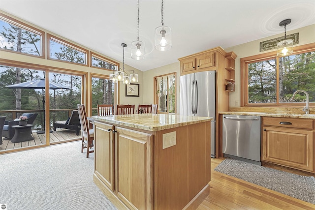 224 Island View Dr, Traverse City, MI 49696 - kitchen with stainless steel appliances, a sink, a chandelier, light stone countertops, and vaulted ceiling