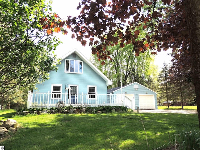 1117 Lincoln Dr, Lake Isabella, MI 48893 - rear view of house featuring an outdoor structure, a detached garage, and a lawn
