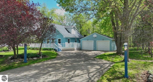 1117 Lincoln Dr, Lake Isabella, MI 48893 - cape cod house with a detached garage, an outdoor structure, a front yard, and a wooden deck