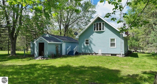 1117 Lincoln Dr, Lake Isabella, MI 48893 - back of property with a lawn and view of wooded area