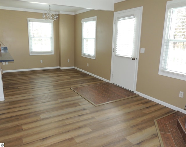 1117 Lincoln Dr, Lake Isabella, MI 48893 - entryway with a chandelier, baseboards, wood finished floors, and ornamental molding