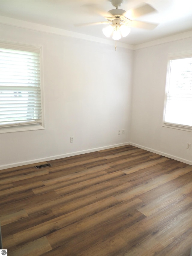 1117 Lincoln Dr, Lake Isabella, MI 48893 - spare room with ceiling fan, crown molding, dark wood-style floors, and baseboards