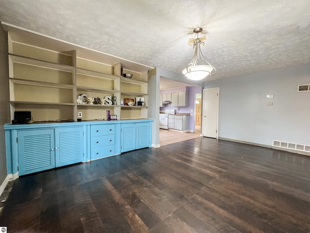 660 N Michigan Ave, Manton, MI 49663 - unfurnished living room with a textured ceiling, dark wood-style flooring, and baseboards