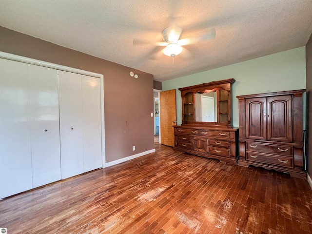 660 N Michigan Ave, Manton, MI 49663 - unfurnished bedroom with dark wood finished floors, a closet, a textured ceiling, baseboards, and ceiling fan