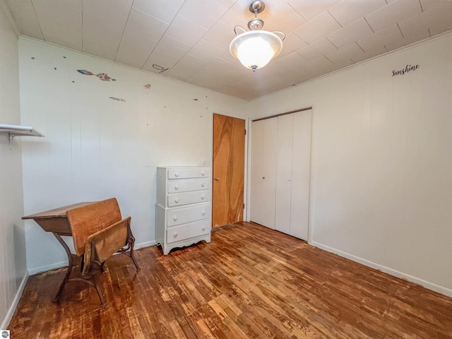 660 N Michigan Ave, Manton, MI 49663 - unfurnished bedroom featuring wood-type flooring, a closet, and crown molding