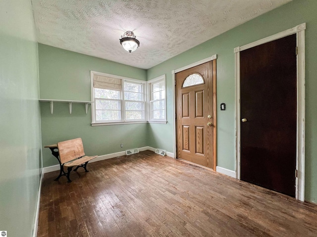 660 N Michigan Ave, Manton, MI 49663 - foyer entrance featuring hardwood / wood-style floors, a textured ceiling, and baseboards
