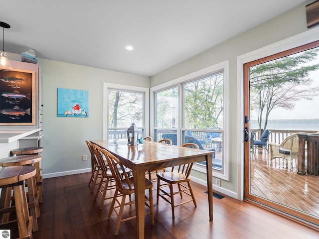 5467 Lakeview Dr, Interlochen, MI 49643 - dining area featuring wood-type flooring, baseboards, recessed lighting, and a water view