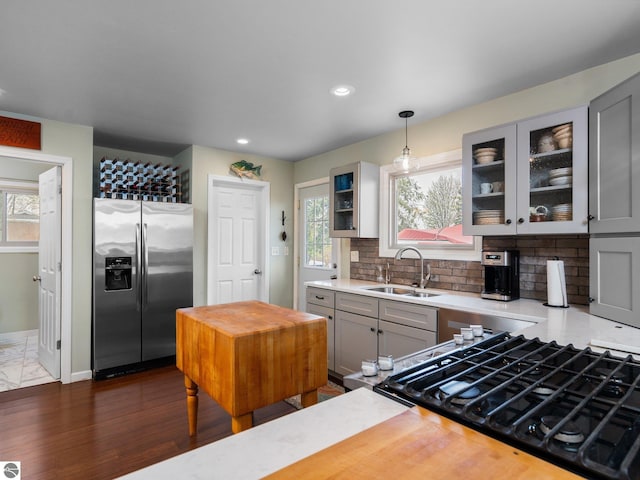 5467 Lakeview Dr, Interlochen, MI 49643 - kitchen with stainless steel fridge, a sink, gray cabinets, gas range, and glass insert cabinets