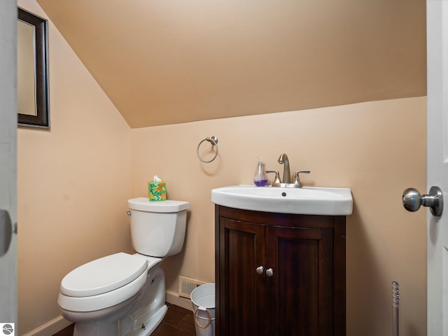 5467 Lakeview Dr, Interlochen, MI 49643 - half bath featuring baseboards, toilet, vaulted ceiling, and vanity