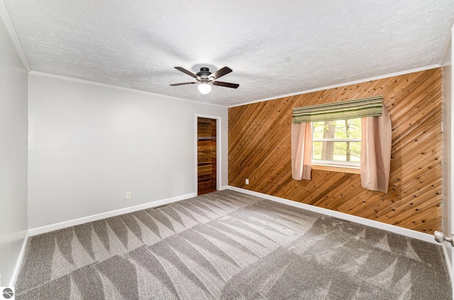 11749 Birch Dr, Lakeview, MI 48850 - spare room featuring baseboards, wood walls, carpet floors, ornamental molding, and ceiling fan
