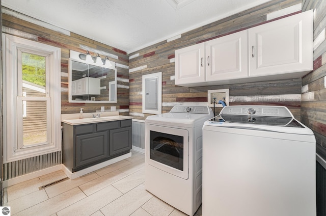 11749 Birch Dr, Lakeview, MI 48850 - washroom featuring separate washer and dryer, cabinet space, electric panel, and light tile patterned flooring
