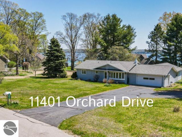 11401 Orchard Dr, Rapid City, MI 48622 - single story home featuring driveway, a front lawn, and an attached garage
