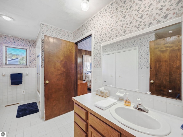 11401 Orchard Dr, Rapid City, MI 48622 - bathroom featuring wallpapered walls, tile walls, tile patterned flooring, vanity, and wainscoting
