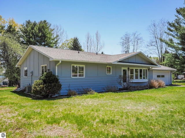 11401 Orchard Dr, Rapid City, MI 48622 - view of front of property featuring board and batten siding, an attached garage, a front yard, and roof with shingles