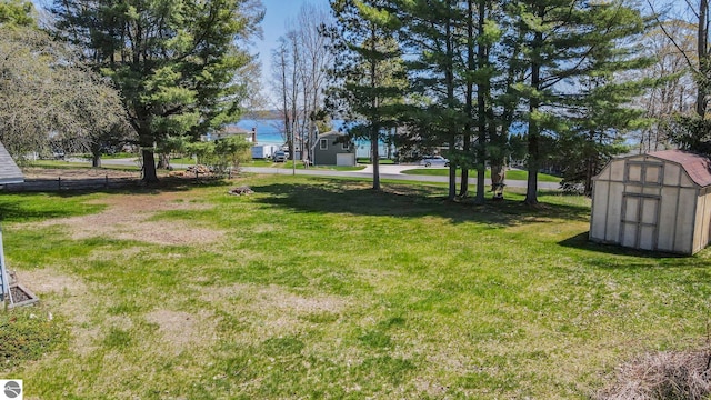 11401 Orchard Dr, Rapid City, MI 48622 - view of green lawn with a storage unit and an outbuilding