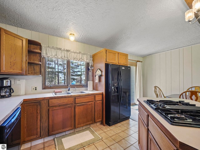 11401 Orchard Dr, Rapid City, MI 48622 - kitchen with black appliances, a sink, light countertops, a textured ceiling, and light tile patterned floors