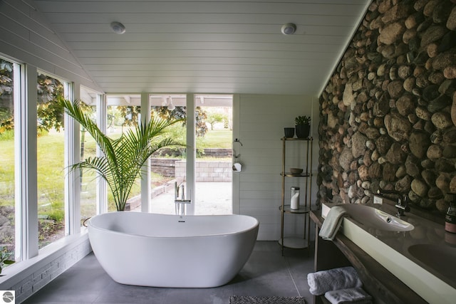 1435 S French Rd, Lake Leelanau, MI 49653 - full bathroom featuring vaulted ceiling, healthy amount of natural light, and a soaking tub