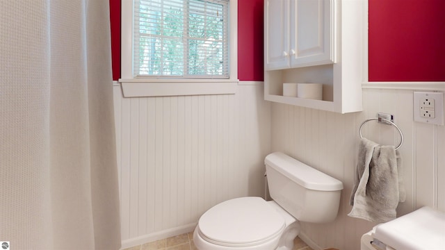 10701 SW Torch Lake Dr, Rapid City, MI 49676 - bathroom featuring a wainscoted wall and toilet