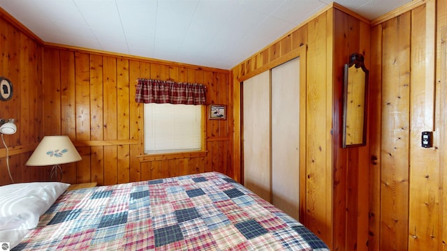10701 SW Torch Lake Dr, Rapid City, MI 49676 - bedroom featuring wood walls and a closet