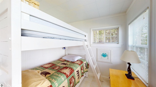 10701 SW Torch Lake Dr, Rapid City, MI 49676 - bedroom featuring tile patterned floors and wooden walls
